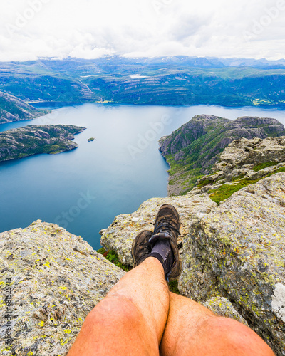 Low section of female hiker sitting on top of fjord