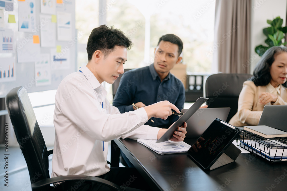Two business workers talking on the smartphone and using laptop at the office.. Two business workers talking on the smartphone and using laptop at the office..