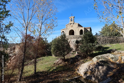 El Burguillo Reservoir, Avila, Spain, November 13, 2023: Small hermitage of El Carmen built in stone among the vegetation in the El Burguillo Reservoir, Avila, Spain