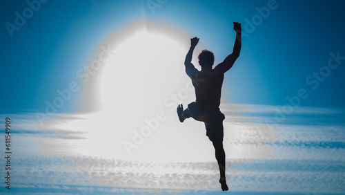 silhouette of a man who jumps while parkour session whit the sun behind