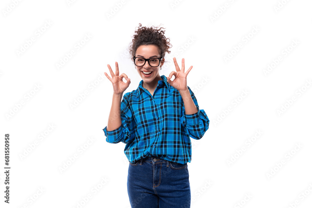 young curly european woman dressed casually in a blue plaid shirt shows a gesture of ok young curly european woman dressed casually in a blue plaid shirt shows a gesture of ok