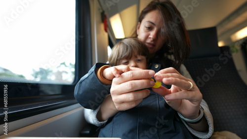 Focused mother guiding her son in counting during a train journey, embodying the essence of homeschooling and childhood learning on-the-go photo
