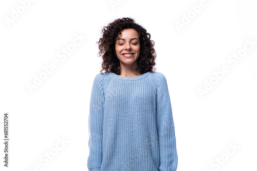 young well-groomed woman with curled hair is dressed in a blue sweater © Ivan Traimak
