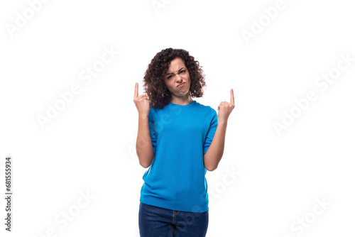 a young woman with a curly hairstyle above her shoulders is dressed in a blue sweater