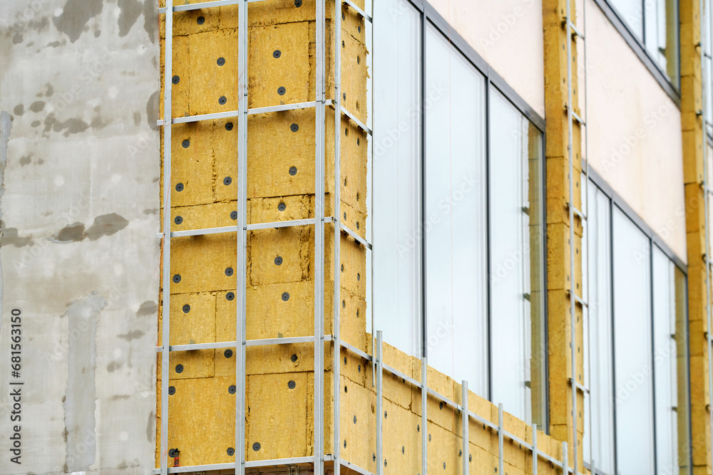 Building renovation, facade wall insulation preparing for cladding. Retrofitting Insulation, external wall slab insulation features high-density outer surface to fixings for cladding.