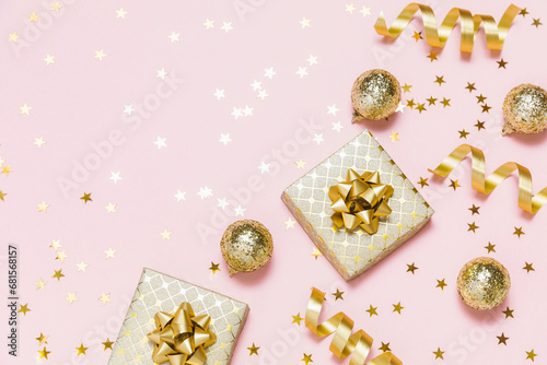 Christmas composition flat lay. Gold party decorations, confetti, gifts on pastel pink background. Christmas, winter holiday, new year concept. Top view, copy space.