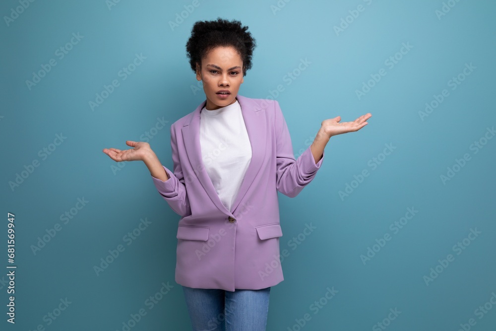young pretty office woman dressed in a jacket doubts looking to the camera on the background with copy space young pretty office woman dressed in a jacket doubts looking to the camera on the background with copy space