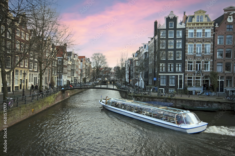 Cruising through Amsterdam canals at sunset in the Netherlands