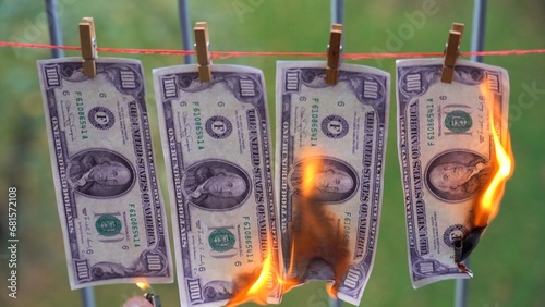 Usa America, New York 11-21-2023 money 100 dollar bills American USA hanging on a thread burn with fire  - inflation and loss of purchasing power of the US dollar