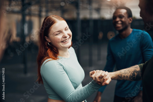 Woman laughing and shaking hands with a partner at the gym photo