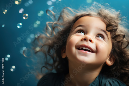 Happy brunette little girl excited looking up in the bubbles © Ari