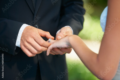 Couple, hands and wedding ring for proposal, commitment or promise in love, care or trust and support at ceremony. Closeup of married man putting jewelry on bride for loyalty, marriage or engagement