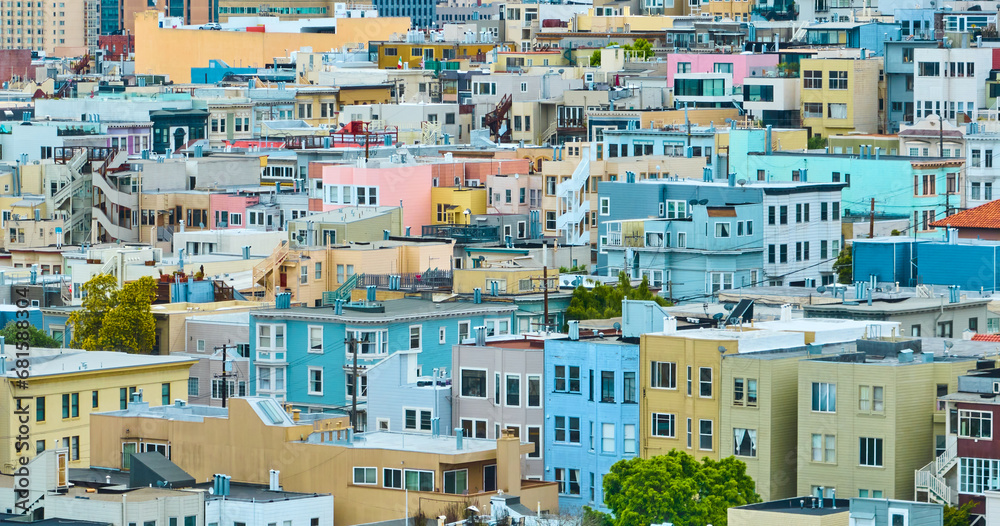 Colorful apartment buildings in messy rows up hill in San Francisco, CA aerial