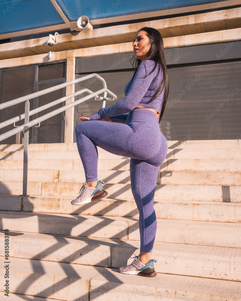 An athletic woman exercising on urban stairs