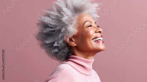 Senior woman exudes joy and confidence against a soft pastel background.