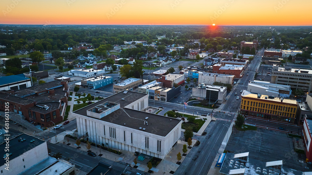 Red sun dawning over Muncie Indiana downtown buildings and courthouse at sunrise, aerial