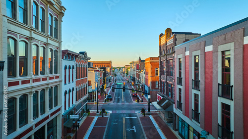 S Walnut Street Muncie, IN at dawn with golden sunrise lighting on city buildings aerial along road photo