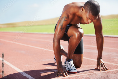 Man, athlete and ready for run on track with practice, training or workout for race. Black person, determination and concentration on face for go, speed and fast for athletics, sport and performance photo