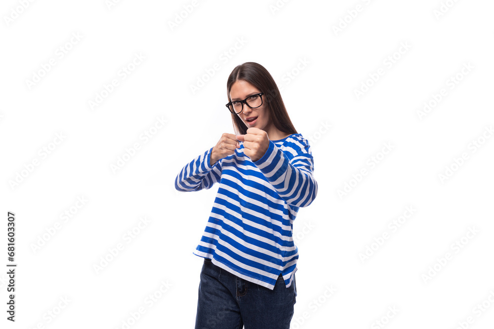portrait of a European pretty brunette young lady in a casual striped sweater and jeans on a white background. people lifestyle concept portrait of a European pretty brunette young lady in a casual striped sweater and jeans on a white background. people lifestyle concept