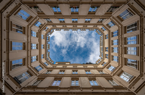 Photography Paris, France - 11 21 2023: View from below of a geometric stone building and blue sky in an inner courtyard