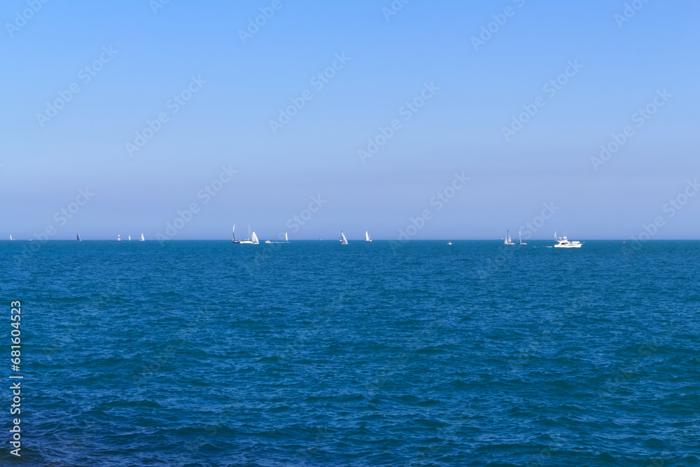 Yachts sailing on Lake Michigan in Chicago. Sailing boats. Blue waves with bright blue sky. Summer scenic landscape background.