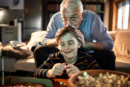 Grandfather watching a movie with his grandson in the living room