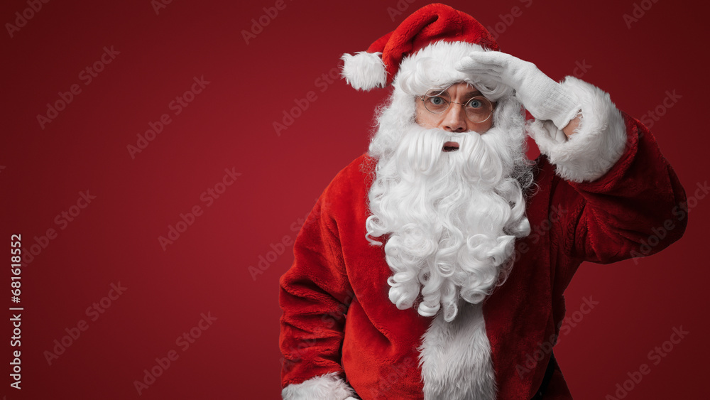 Thoughtful Santa Claus peering over glasses, searching for the naughty or nice Thoughtful Santa Claus peering over glasses, searching for the naughty or nice
