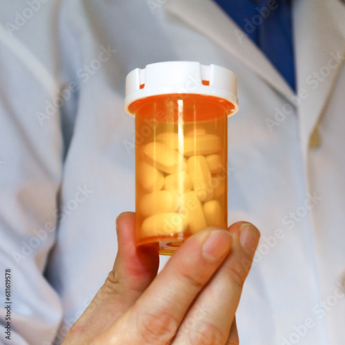 doctor holding pill bottle.