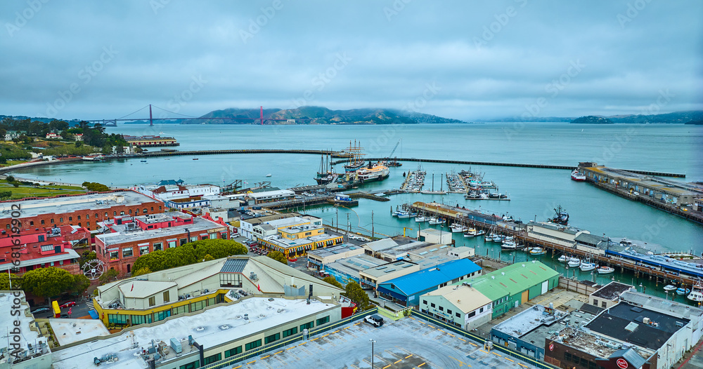 Aquatic Park Cove with Hyde St Pier and docked boats near wharf and distant Golden Gate Bridge aerial, San Francisco, CA - obrazy, fototapety, plakaty 