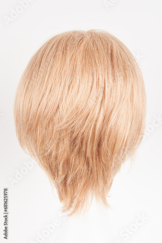 Natural looking blonde fair wig on white mannequin head. Short hair cut on the plastic wig holder isolated on white background, back view.