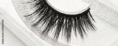 Black long false eyelashes close-up on white background. Self-adhesive eyelashes, eyelash extensions, mascara effect. photo