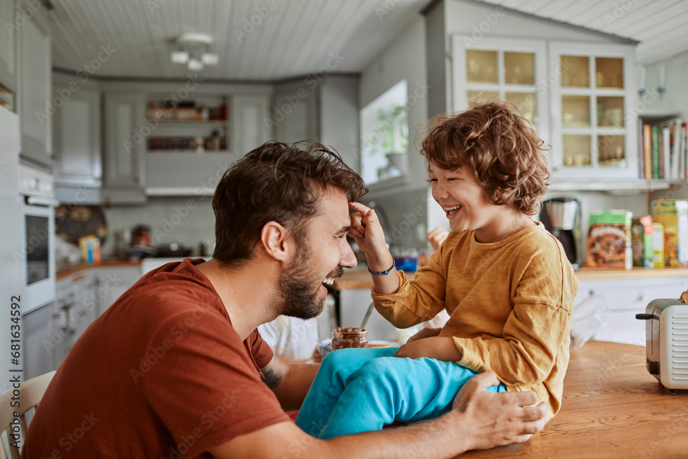 Fototapeta premium Happy father and small son have fun with food in the kitchen