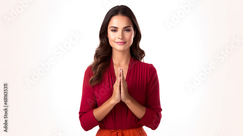 On a white background, a young woman wearing a red top and skirt is shown doing the namaste gesture. 