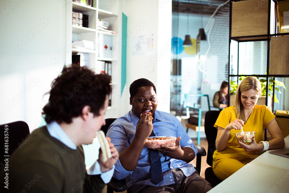 Diverse young people sharing corporate lunch at the office Diverse young people sharing corporate lunch at the office