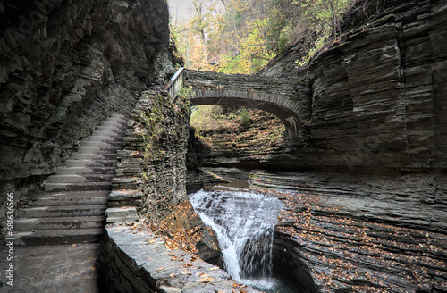 rainbow falls at watkins glen state park (waterfall in a gorge with stone bridge, staircase, glacial layered rock formation) falling water, stream, autumn colors, leaves changing, fall foliage detail photo