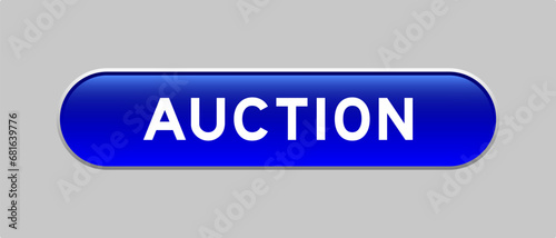 Blue color capsule shape button with word auction on gray background