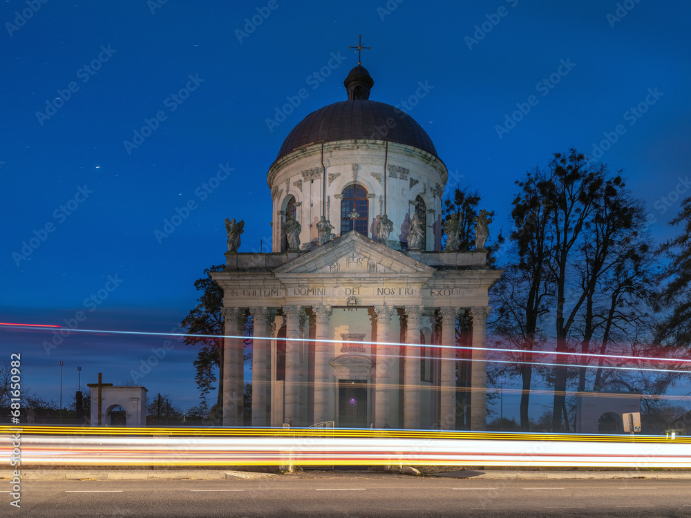 landscape view to baroque cathedral in night time with car trails 