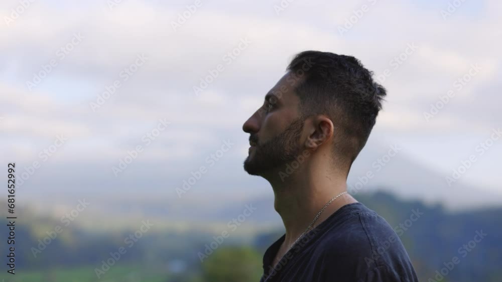 Side View of the Bearded Multiracial Man Standing Outdoors, Looking Away, Dreaming. Handsome Tourist Posing in the Mountains Background. People Concept. Side View of the Bearded Multiracial Man Standing Outdoors, Looking Away, Dreaming. Handsome Tourist Posing in the Mountains Background. People Concept.