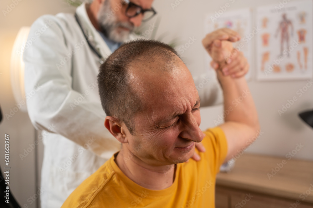 A man with shoulder pain goes to the doctor, The doctor diagnoses the patient's arm pain and shoulder pain. Concept of physical therapy and rehabilitation. Physiotherapist doing healing treatment A man with shoulder pain goes to the doctor, The doctor diagnoses the patient's arm pain and shoulder pain. Concept of physical therapy and rehabilitation. Physiotherapist doing healing treatment