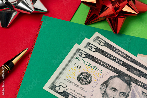 Cash money and holiday greeting cards. Holiday tipping, gratuity, Christmas gift and charitable donation concept. photo