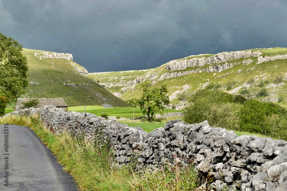 The rugged landscape of the Yorkshire Dales under a dark grey sky. 