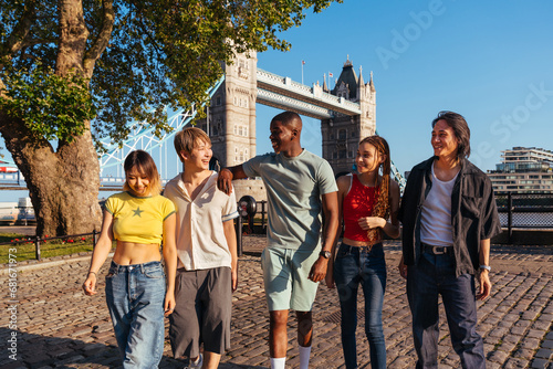 Multiracial group of happy young friends bonding in London city - Multiethnic teens students meeting and having fun in Tower Bridge area, UK - Concepts about youth lifestyle, travel and tourism photo