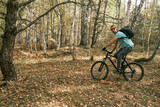 An active lifestyle.Cyclist with a backpack on a mountain bike in the autumn forest