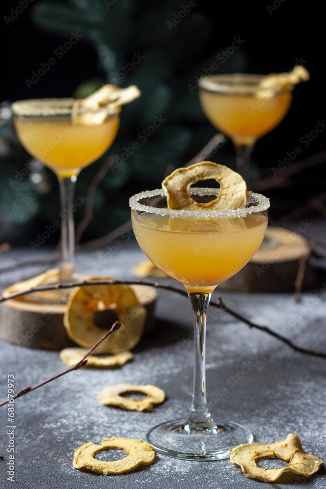 Fototapeta premium A set of three apple cocktails on a dark background. Apple cider, wine, New Year's treat, festive drink for Christmas. Yellow smoothie, apple chips. Festive mood.