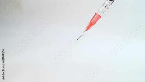 Close-up of an insulin syringe with a needle dripping medicine