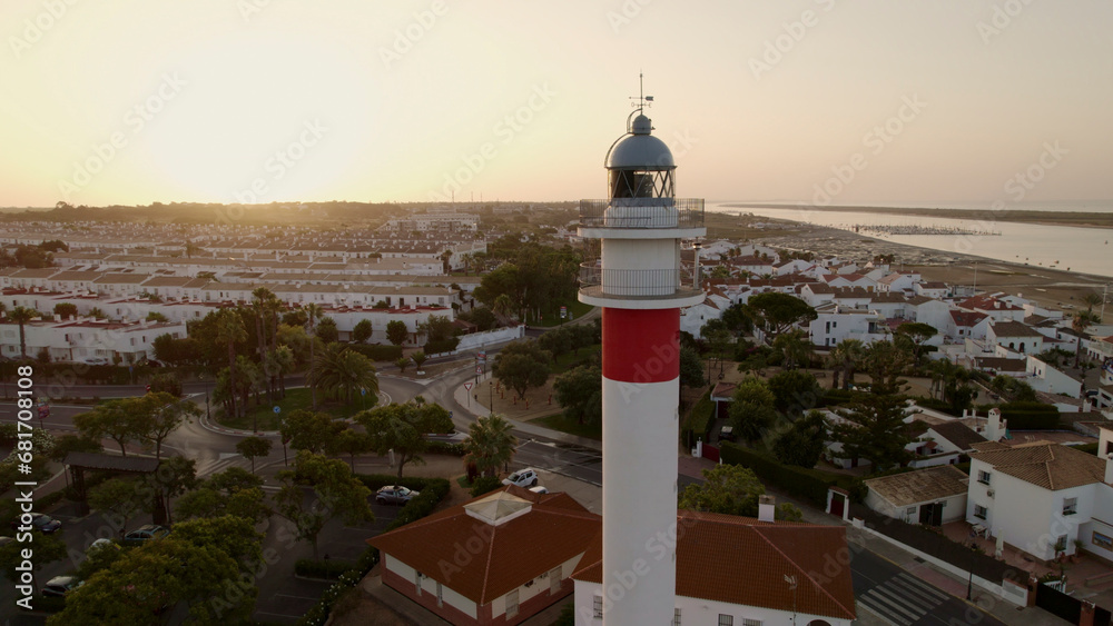 Lighthouse next to fishing village at dawn. Marina aerial view. Spain.
