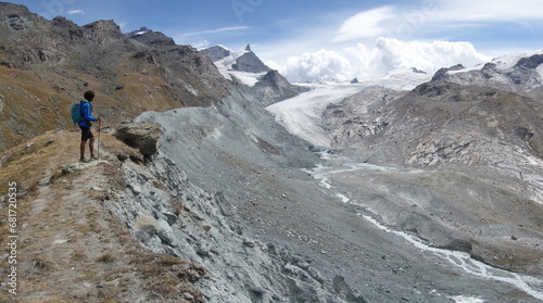 Randonneur au sommet d'une moraine admirant la vue sur les montagnes environnantes et le glacier (Alpes, Suisse)