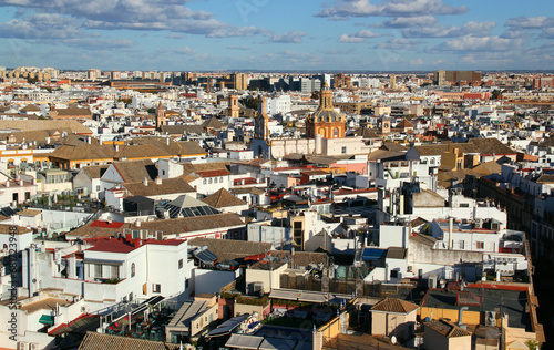 Panoramic view of the city of Seville (Andalusia region, southern Spain) with snow-white houses and churches against a blue sky with clouds