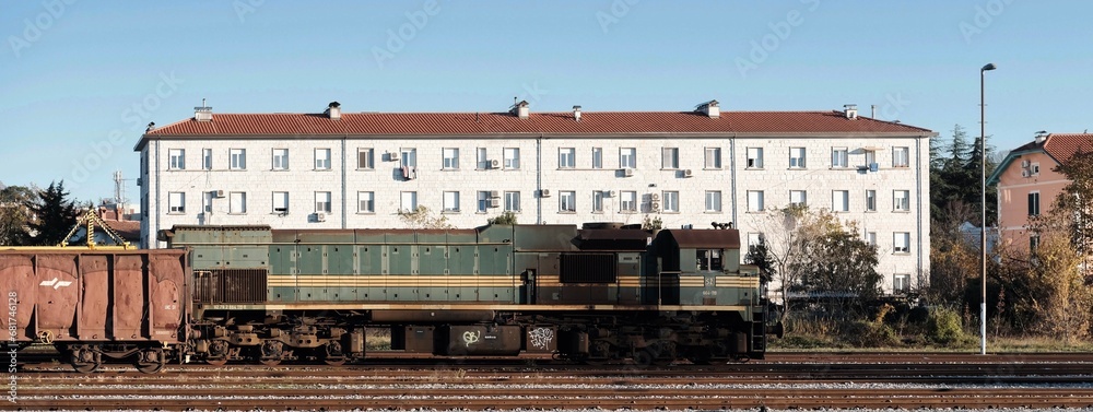 Locomotiva ferma in stazione con lo sfondo di un grande edificio 