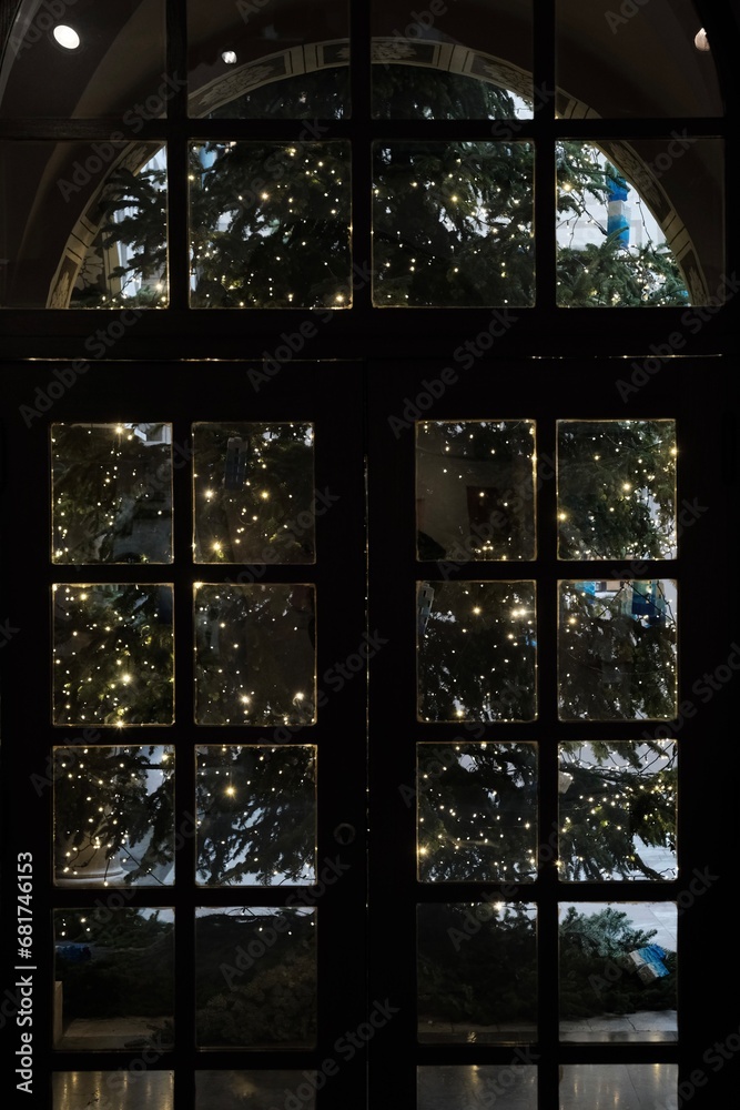 Albero di Natale visto attraverso una vetrata a forma di arco
